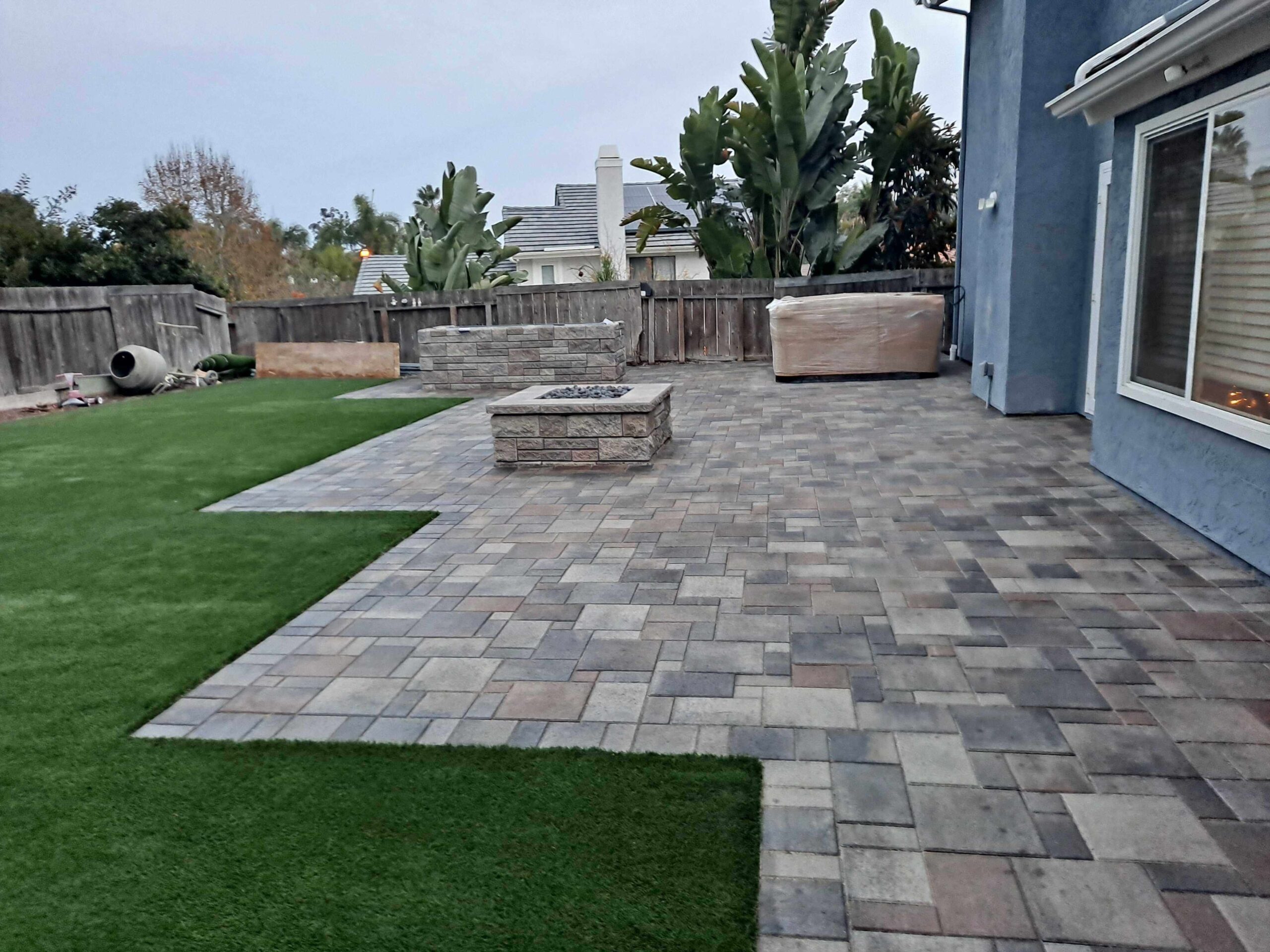 photo of a paver patio and lawn with artificial turf