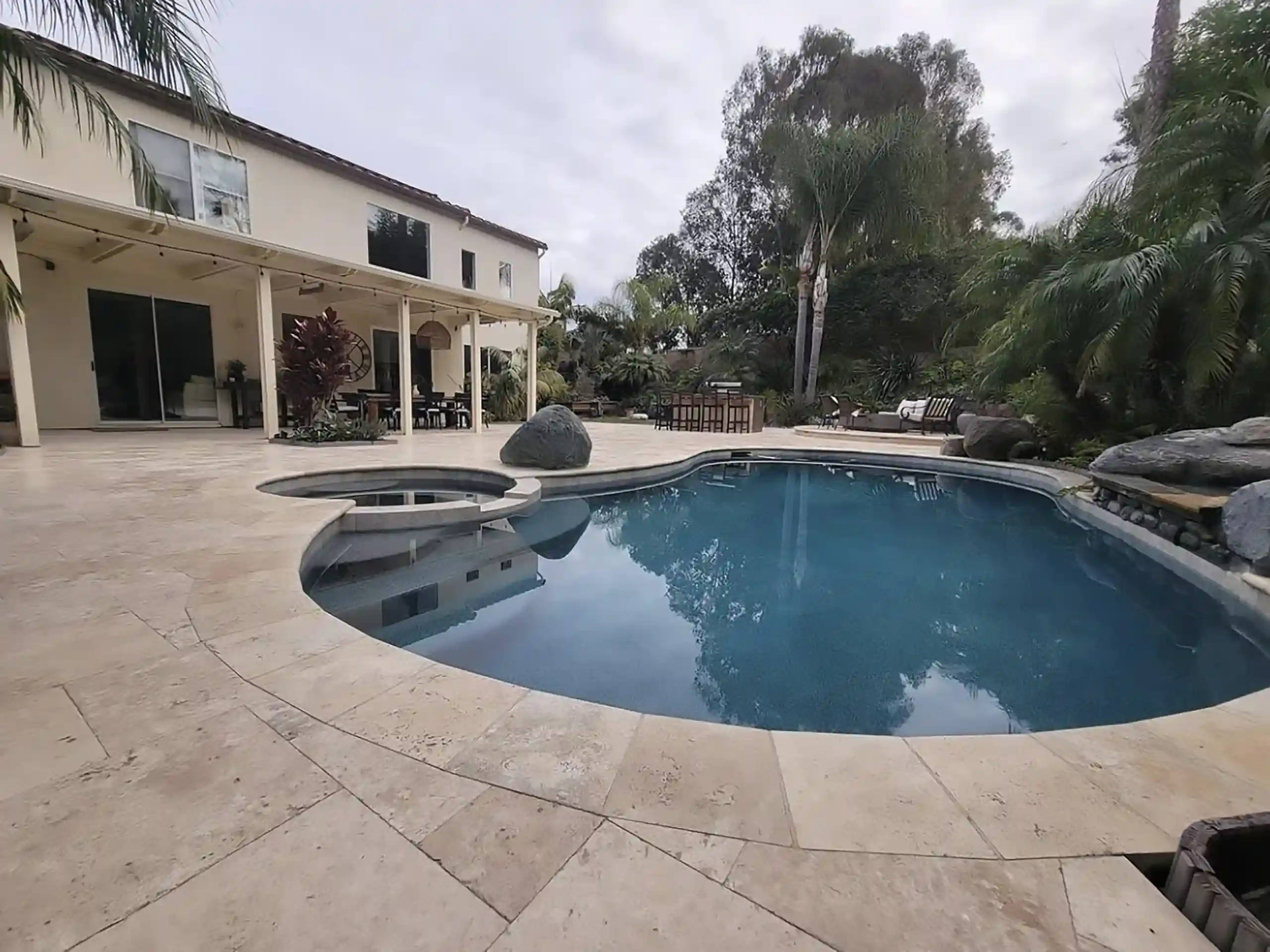 photo of a paver pool deck with partially covered patio