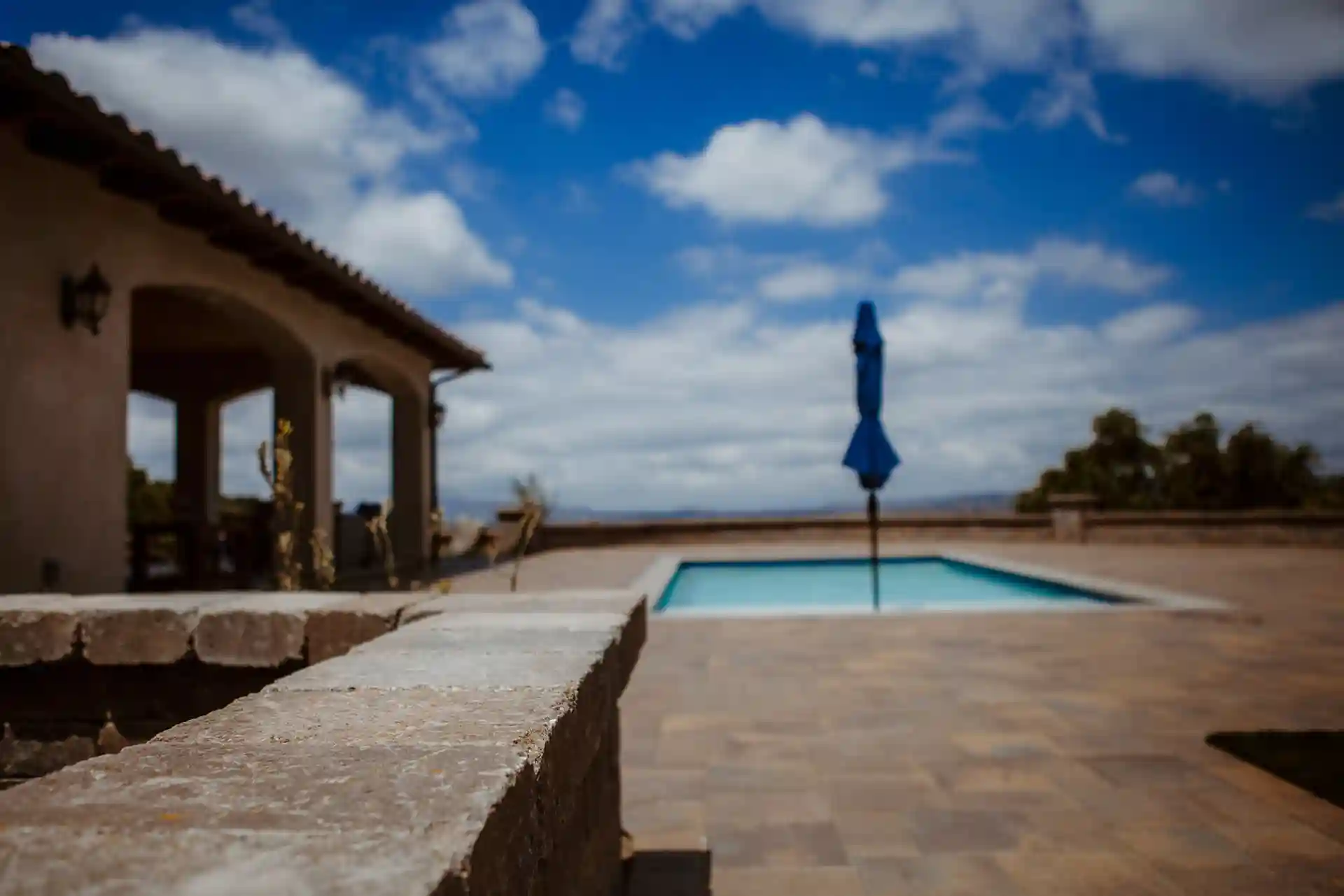 photo of a paver pool deck with partially covered patio 